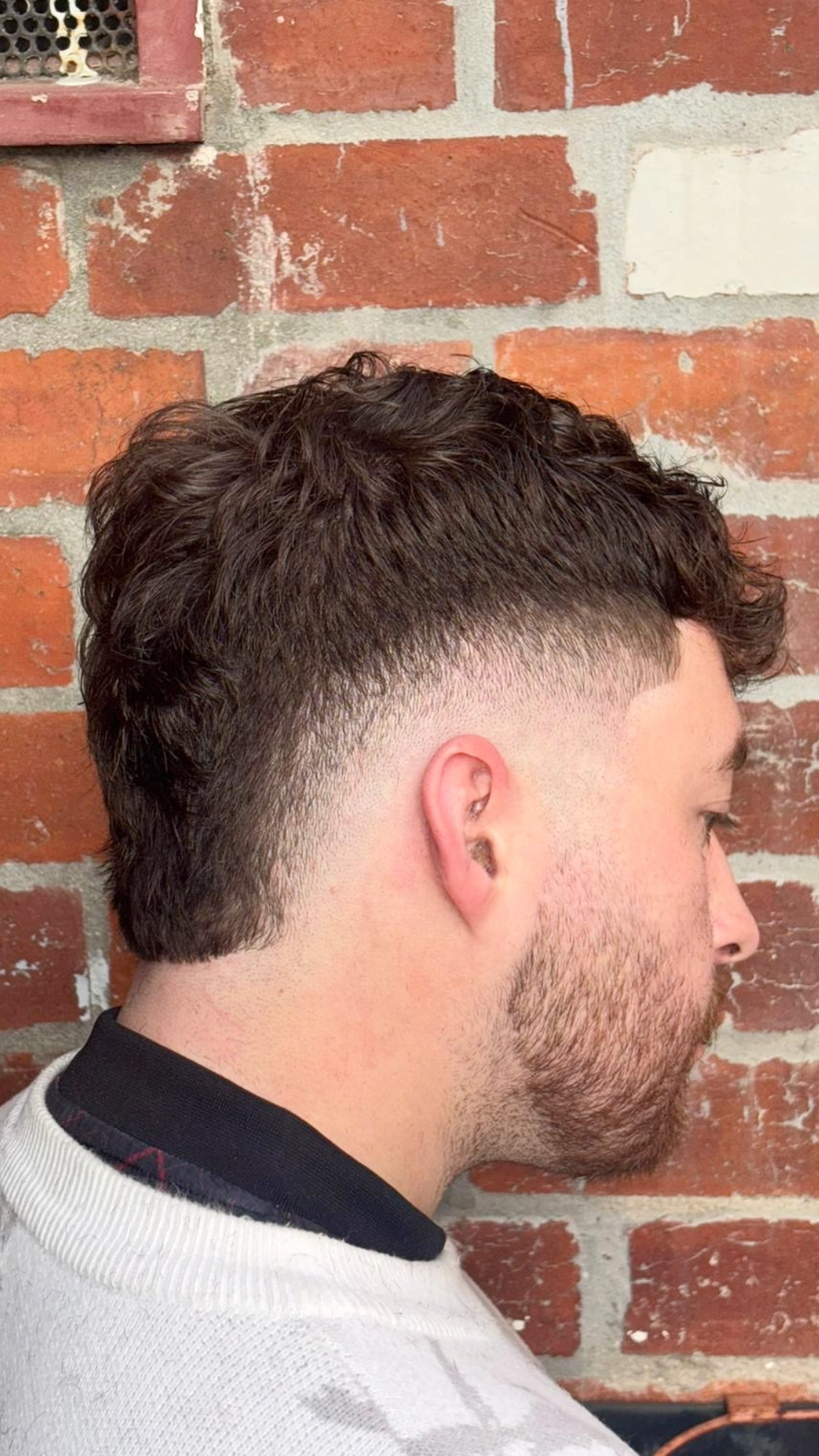 Barber blending a clean fade haircut in Melbourne